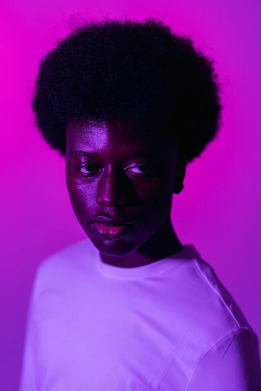 a woman with dark skin and afro looks into the camera