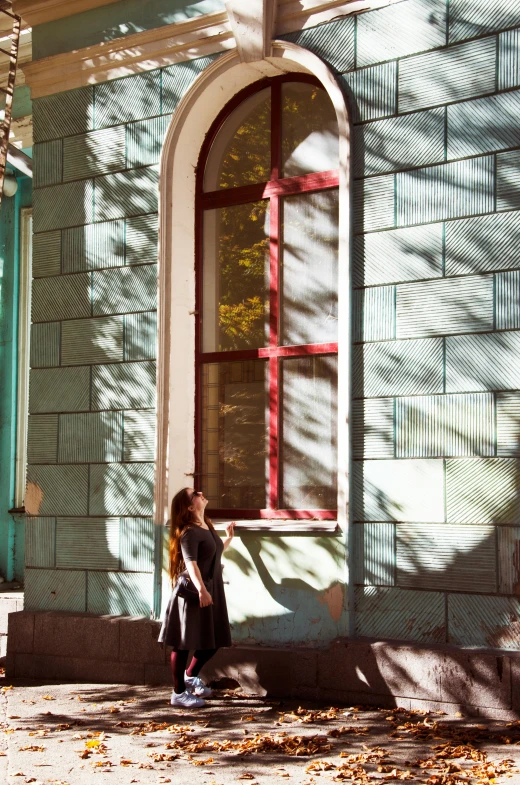 woman standing in front of blue painted old building