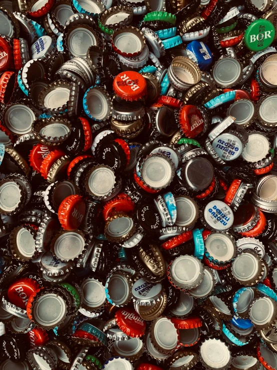 a pile of assorted beer caps sitting on top of each other