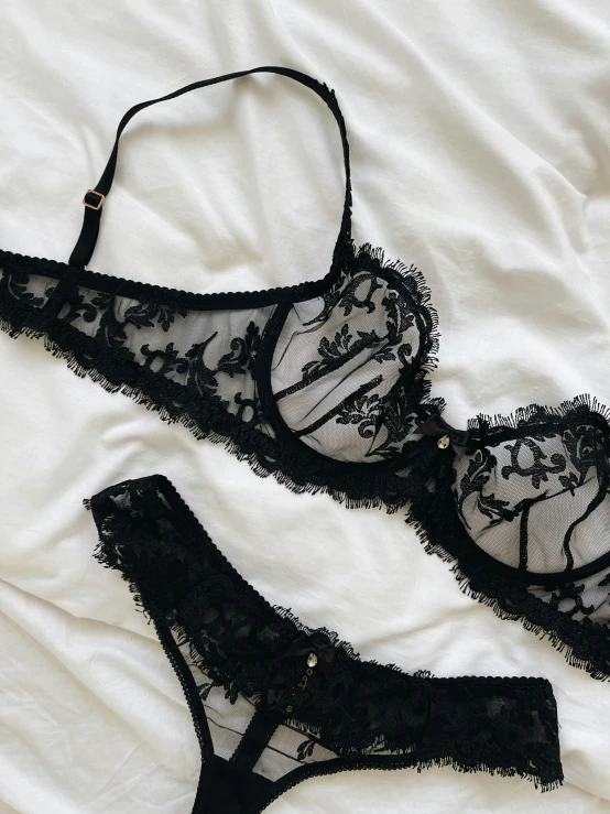 a black lingerie sitting on top of a bed