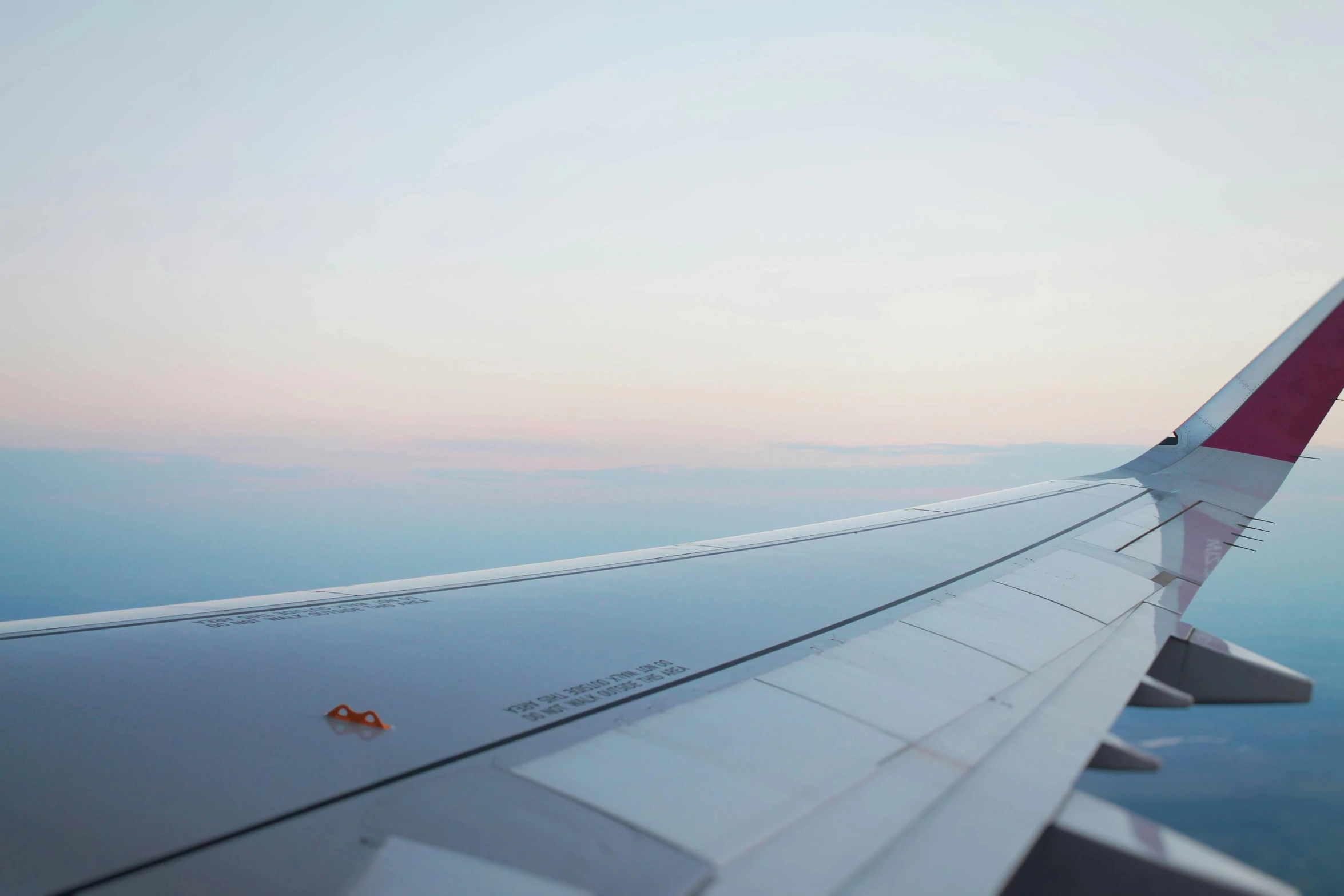 a airplane is flying above the ground and some clouds