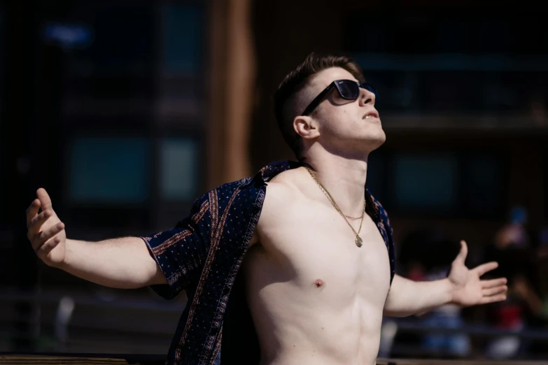 a shirtless man with  on standing next to a brick building