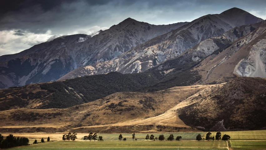 several people are running through the distance with the mountains in the background