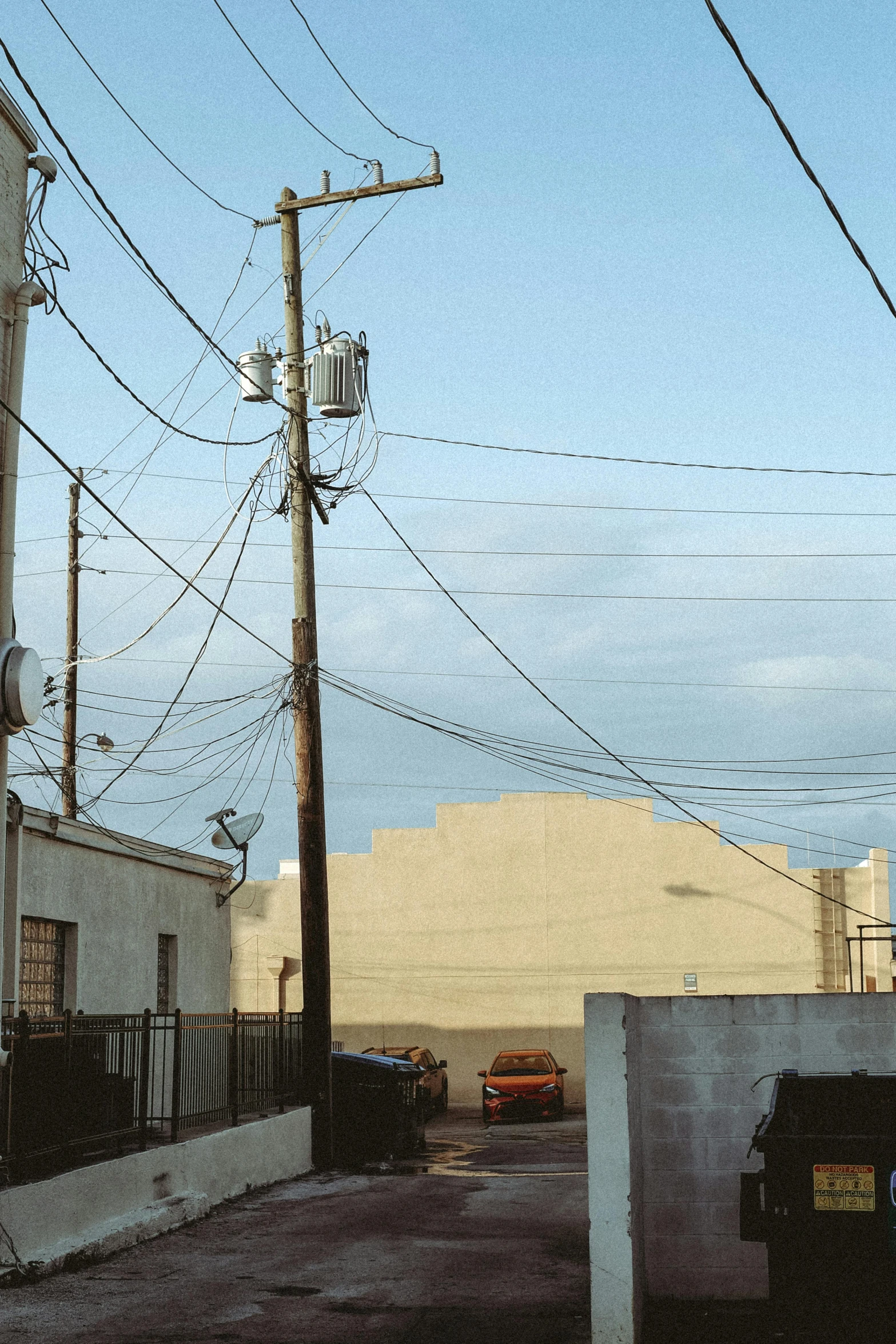 a telephone pole and electric wires on a street