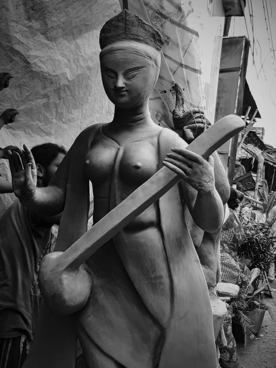 a black and white po of a statue of a woman holding an object