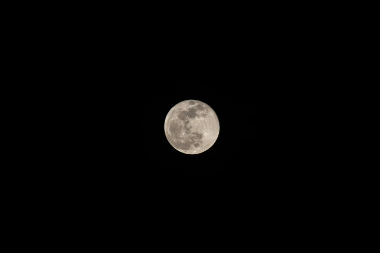 the full moon can be seen across the night sky