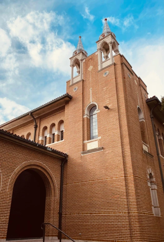 an old brick building that is set under cloudy skies