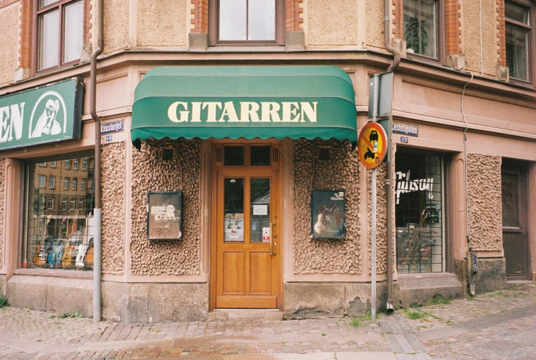 a building with two large doors and a green awning on top