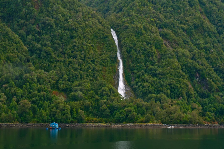 a waterfall flowing over a lush green hillside