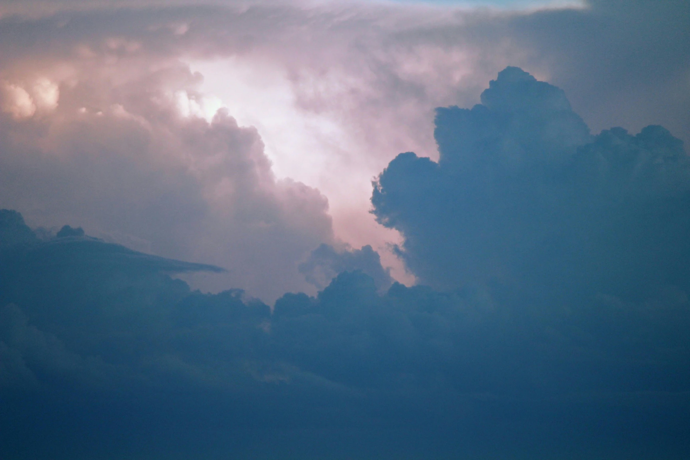 a plane in the sky with a group of clouds