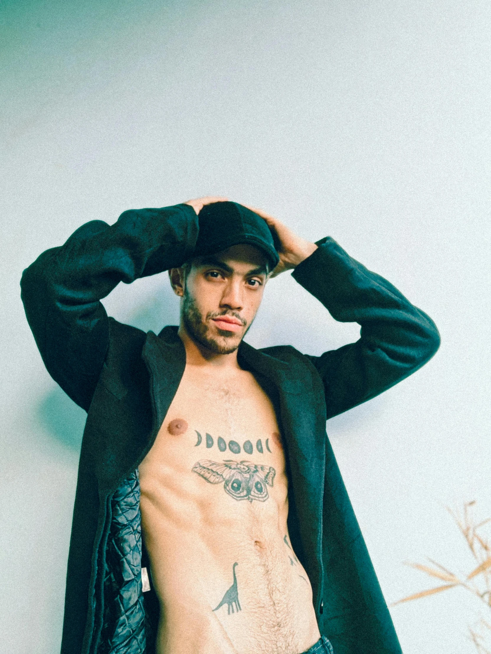 a man with a hat and a tattoo on his upper body