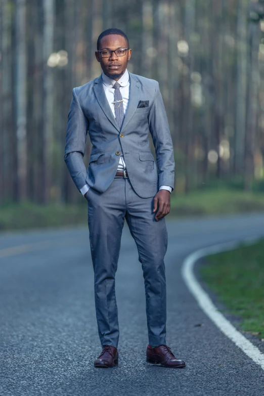 a man wearing a suit standing in the middle of a road