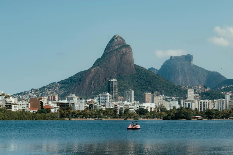 a boat in the water next to a mountain