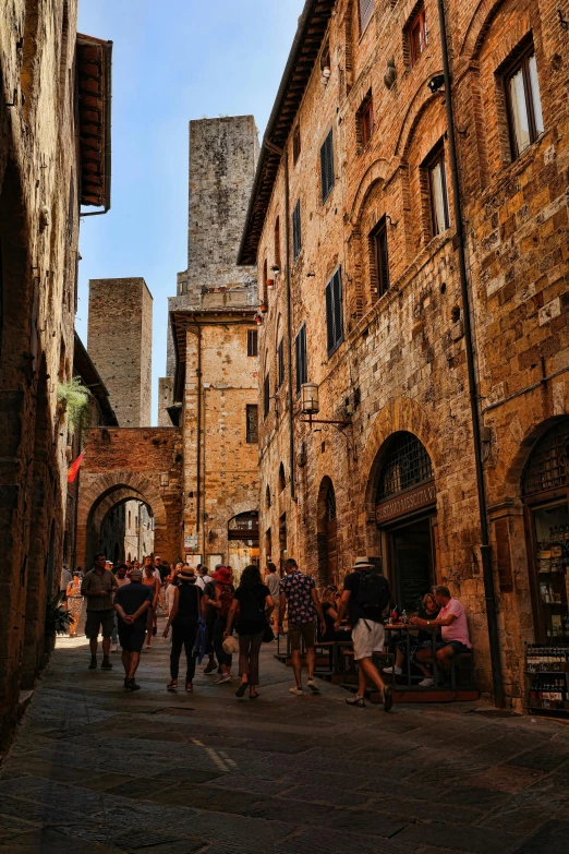people walking down a narrow street in an old european city