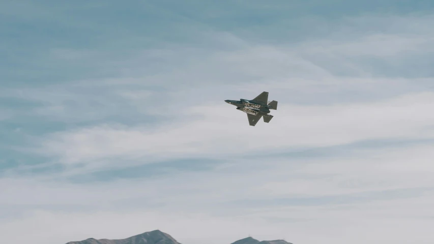 an airplane flies in the sky over mountains