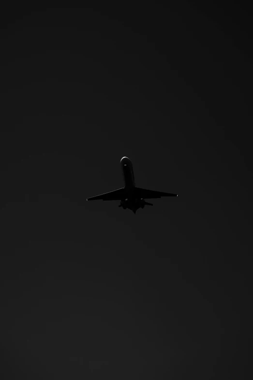 a plane flies through the air on a dark night