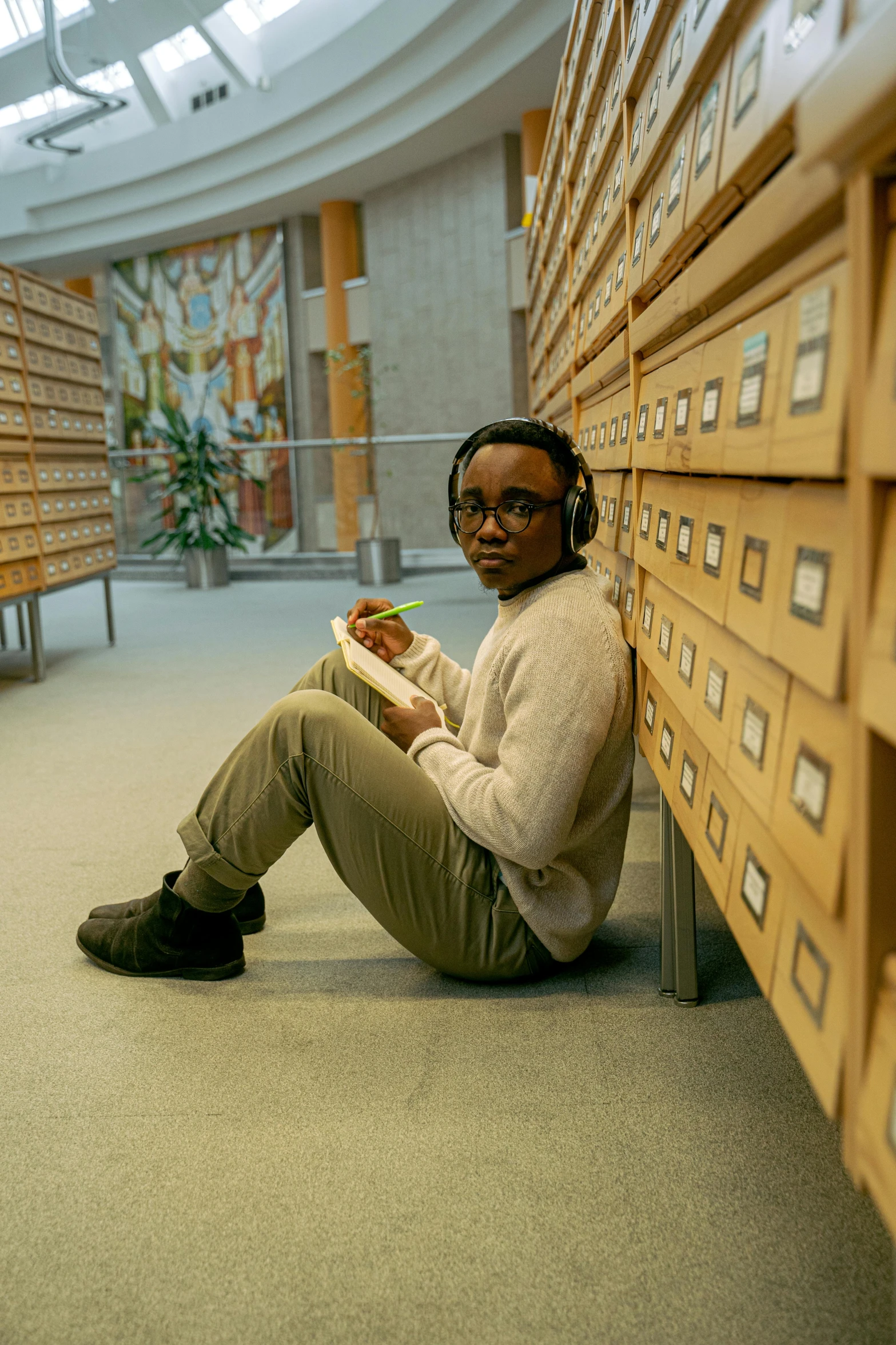 a person is sitting on the ground in a liry with shelves