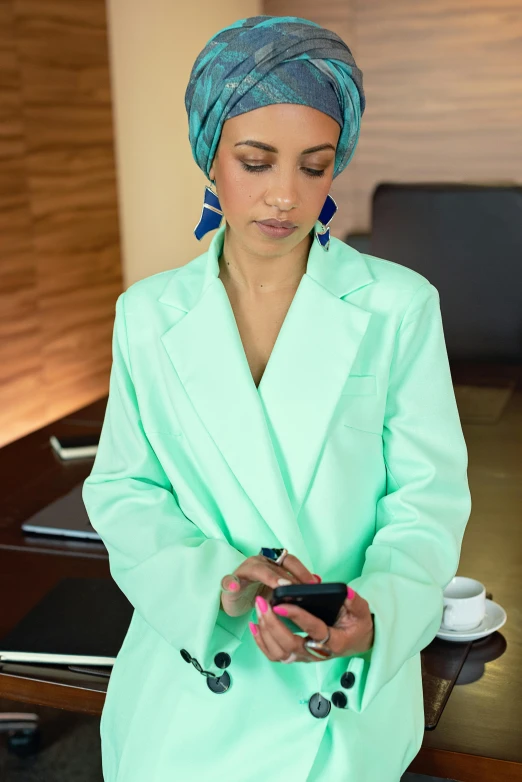 a woman with an turquoise turban using her cellphone