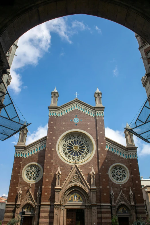 the front view of a church with large windows and a huge arch