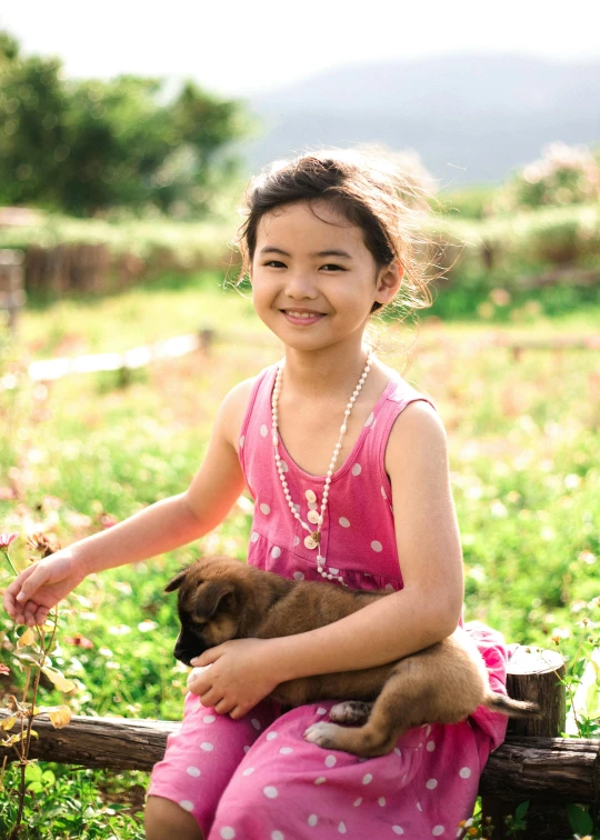 girl with dog in her lap smiling for the camera