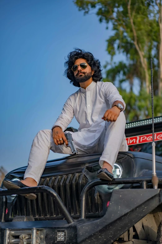 a man sitting on the front of a black jeep