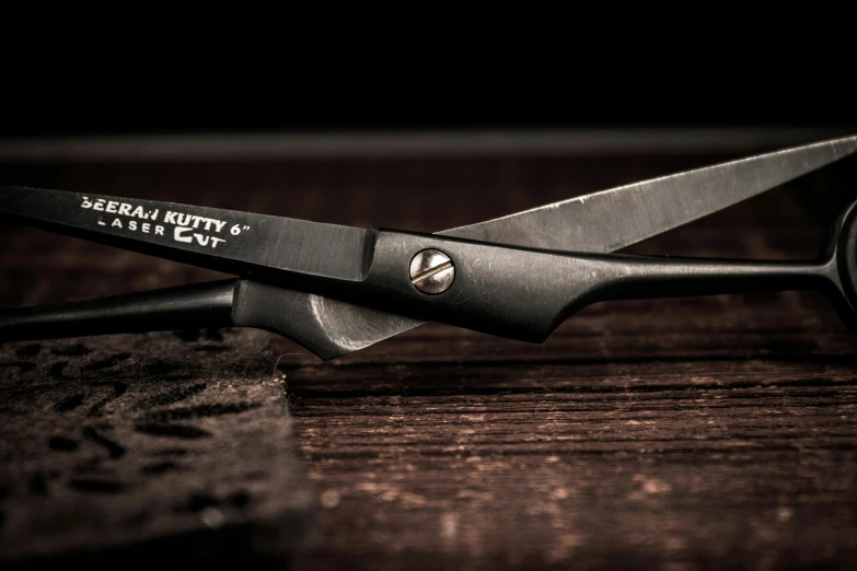 a pair of scissors sitting on top of a wooden table