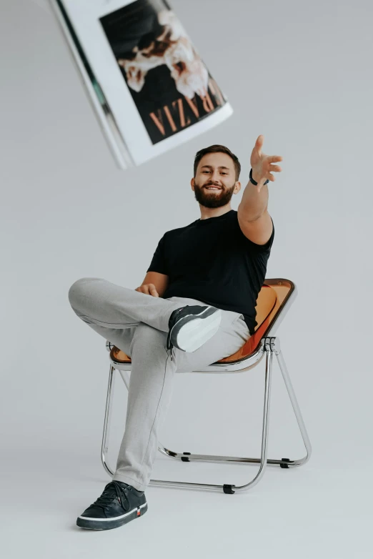 a man sits on a chair with his leg up in the air