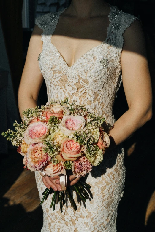 the woman is holding her wedding bouquet outdoors