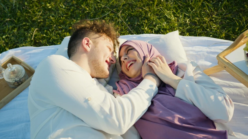 a man and woman are lying together on a blanket