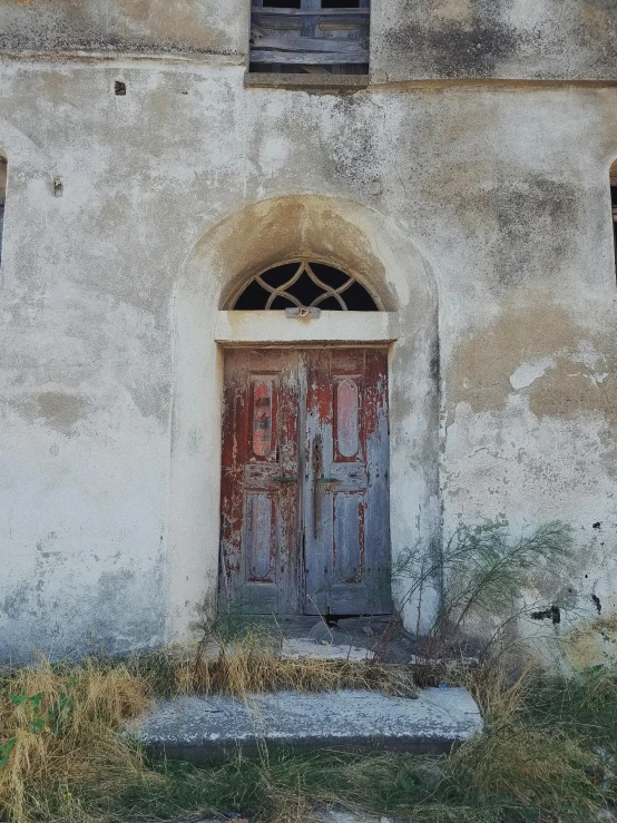 a gray church with a weathered wood door and window