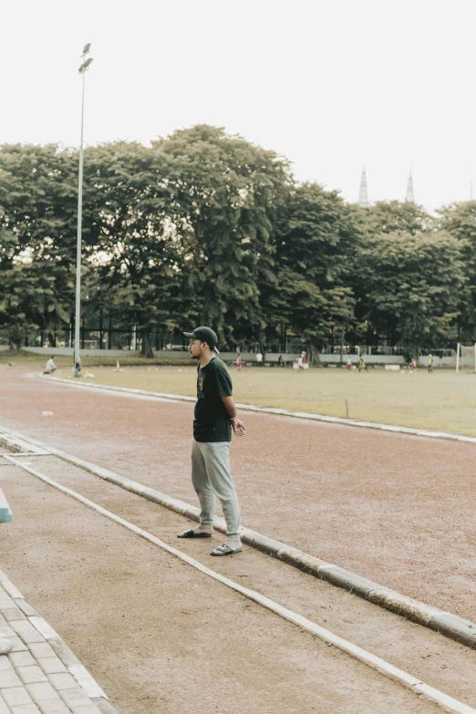 a man is looking down at his shoes while standing on the road