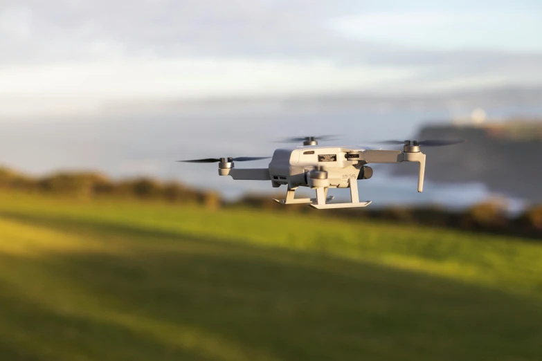 a small white plane flying over green grass