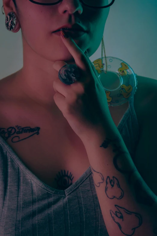 a woman with tattoos is holding her nose