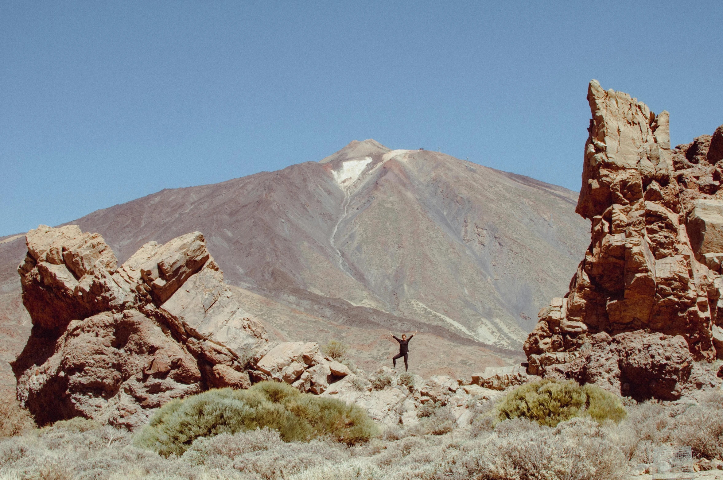 a person walking through the desert near large rocks