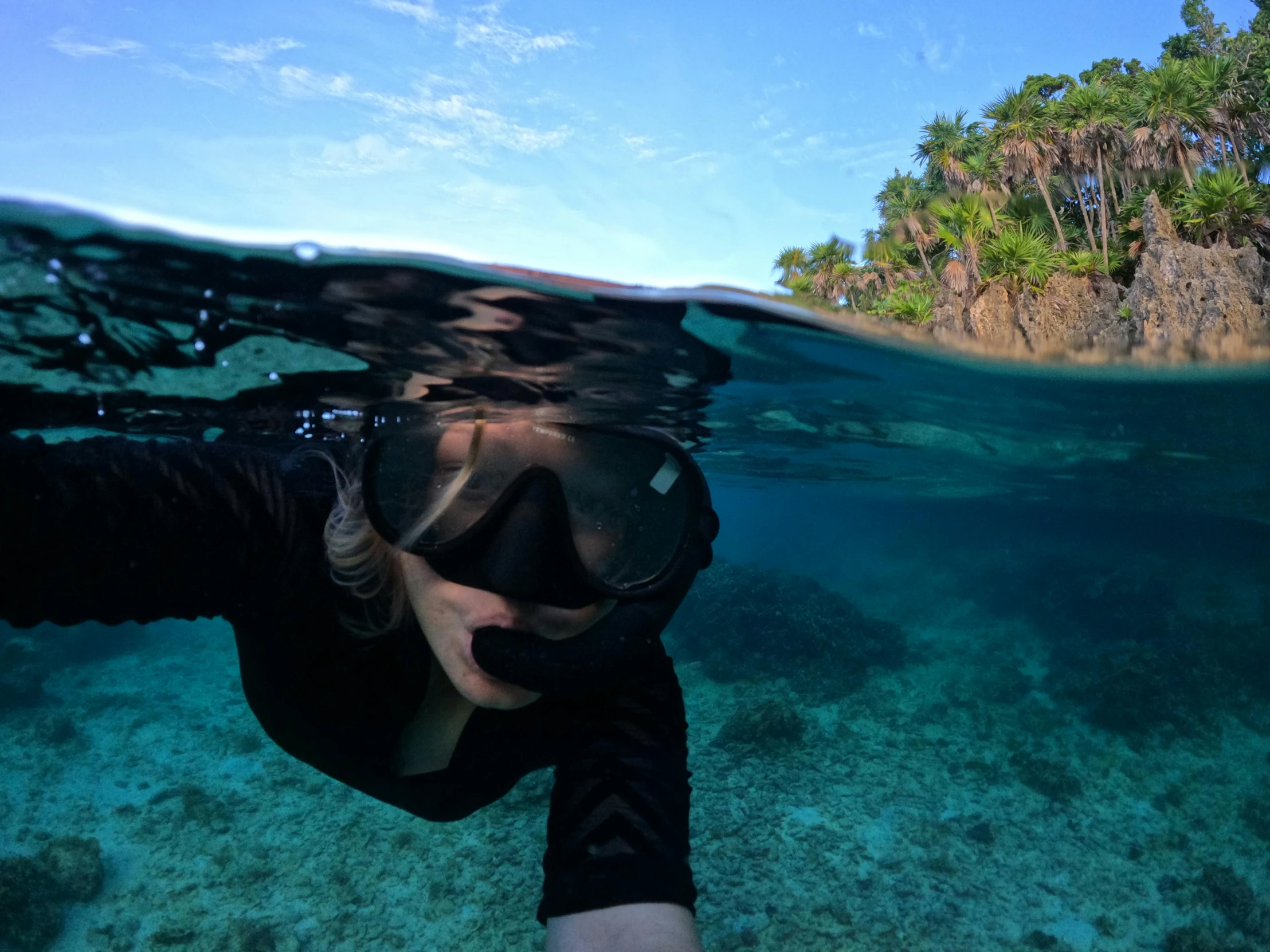 a man underwater diving towards the camera while wearing a diving mask