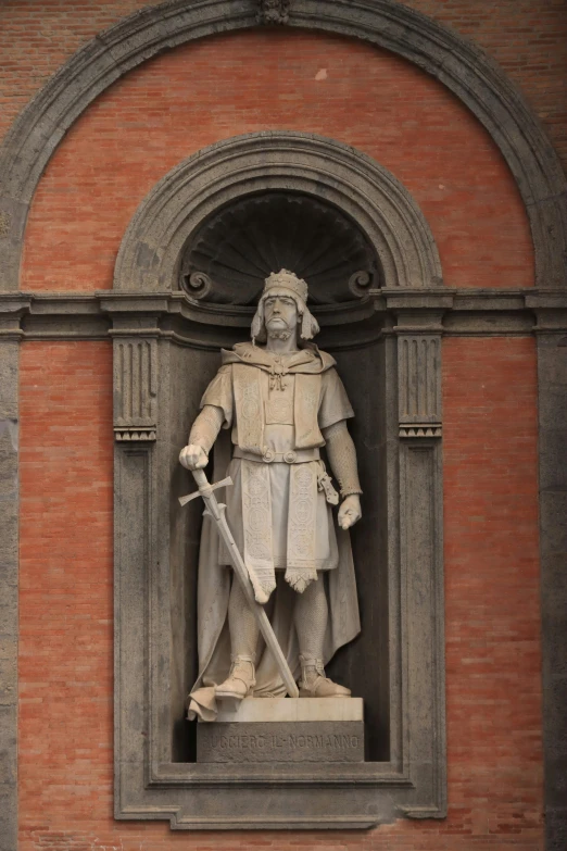 a statue of a person holding a sword is displayed