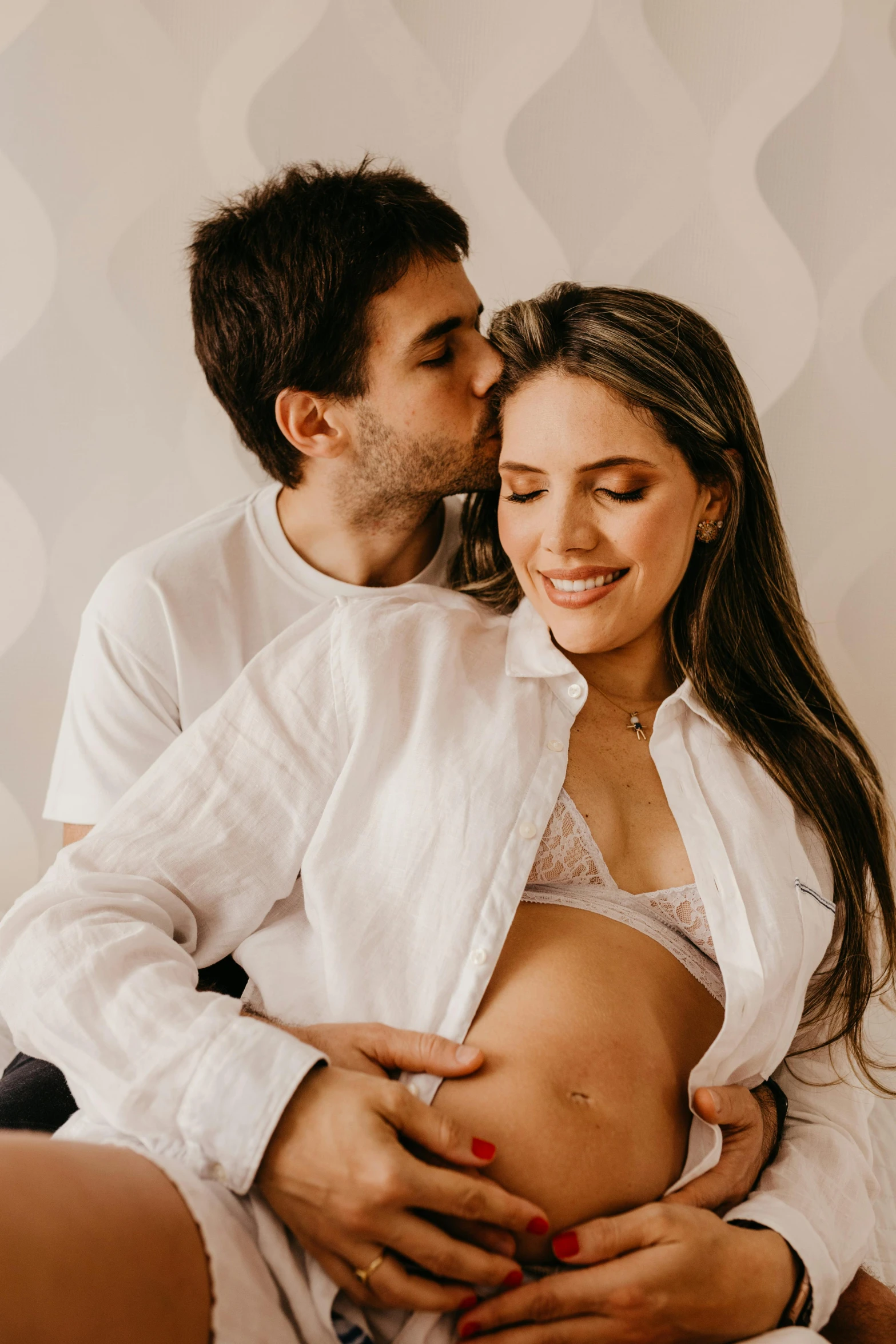 pregnant woman in white panties holding man