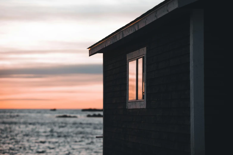 the window of a building sits against an ocean