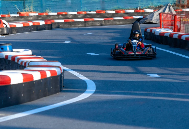 a man driving a go kart car down a street