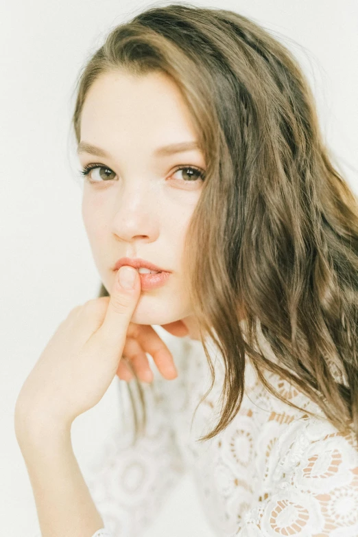 woman posing with hand on her lips looking at camera