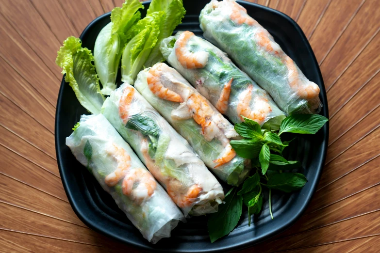 a plate of shrimp spring rolls with lettuce