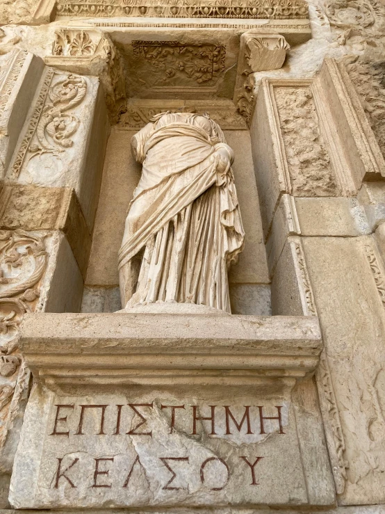 a statue of the goddess posets above greek writing