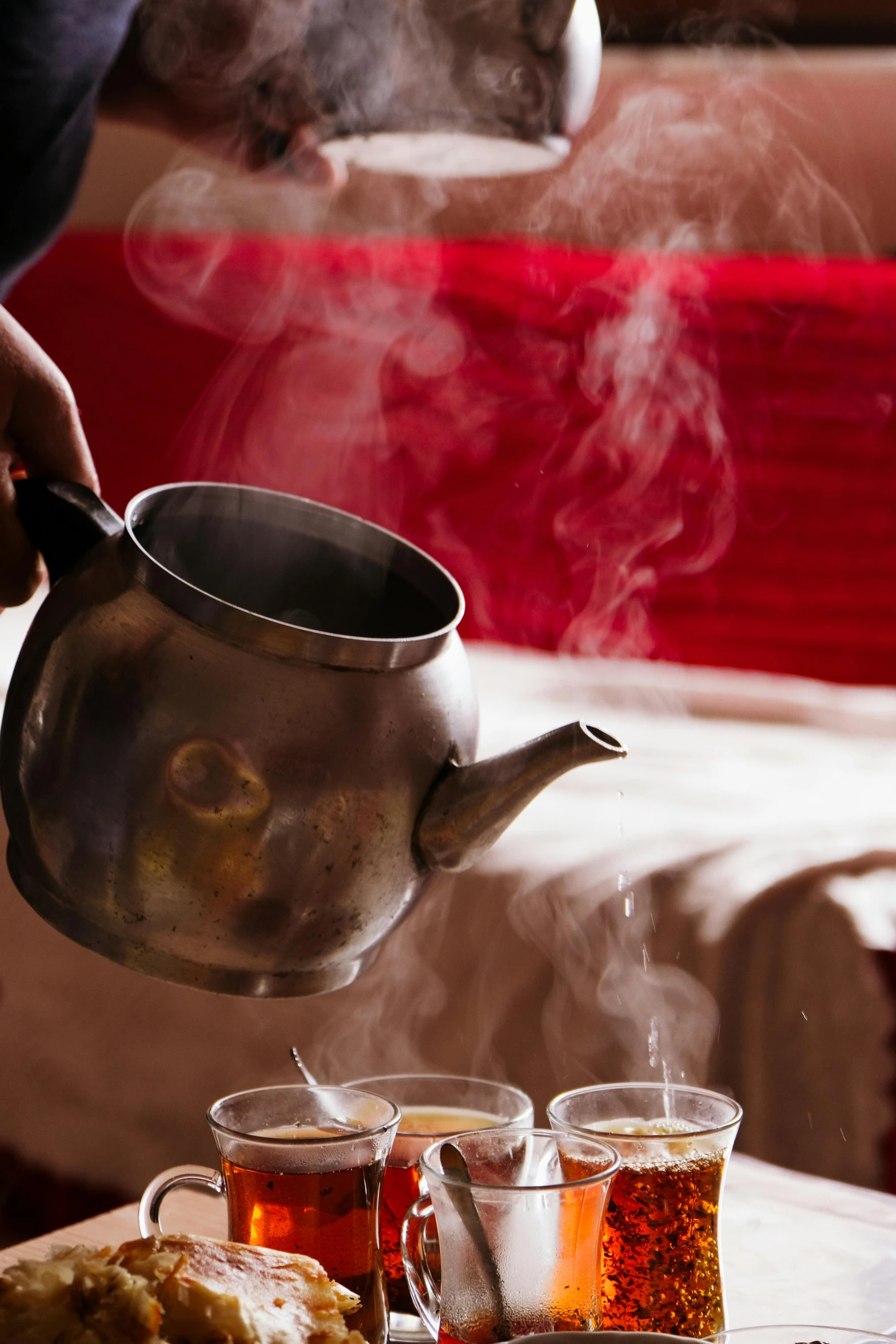 a woman pours tea into cups for tea