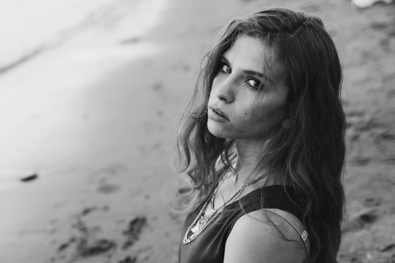 a woman posing on the beach in black and white