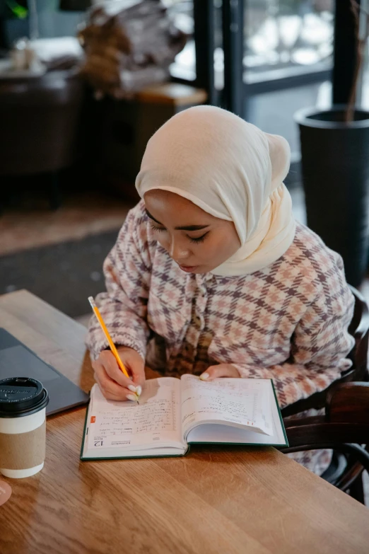 a small child writing while holding a pen