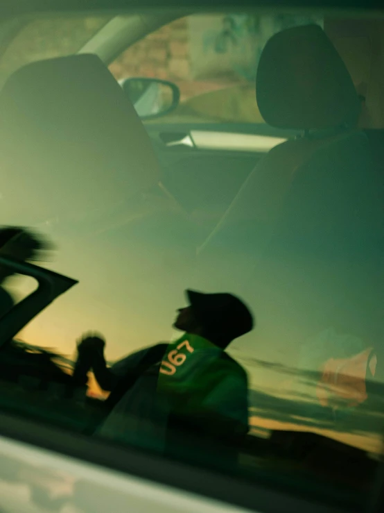 two men sit in the drivers seat of their vehicle