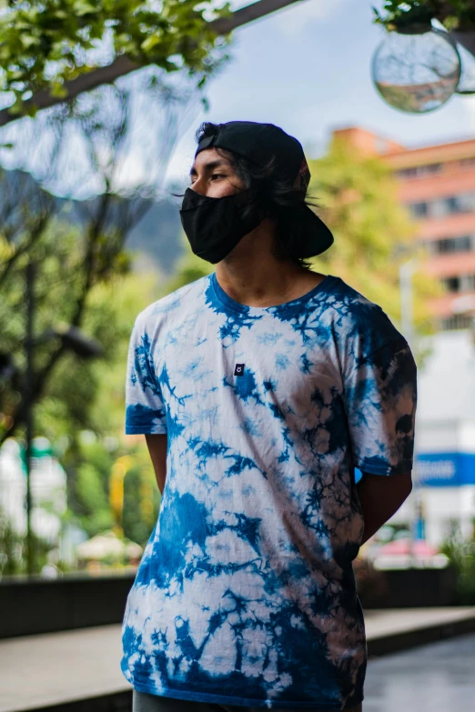 a man standing in the rain with his face covered with a bandanna