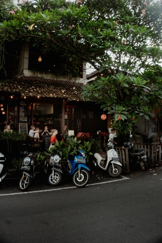 mopeds parked outside of a restaurant on the street