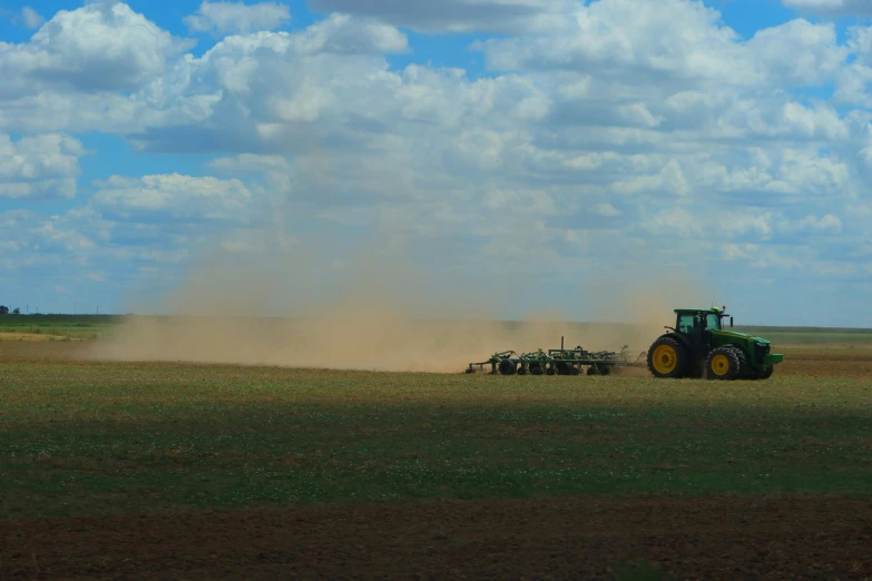 a tractor driving in the grass near a field