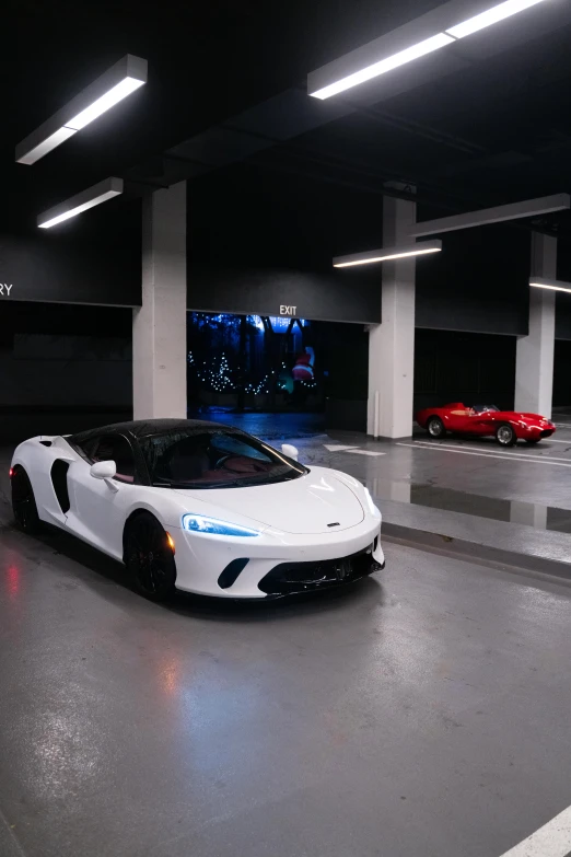 a white sports car driving through a parking garage